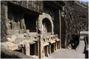 Rock cut entrance with Chaitya Arch for light and ventilation, and relief sculptures at the left.