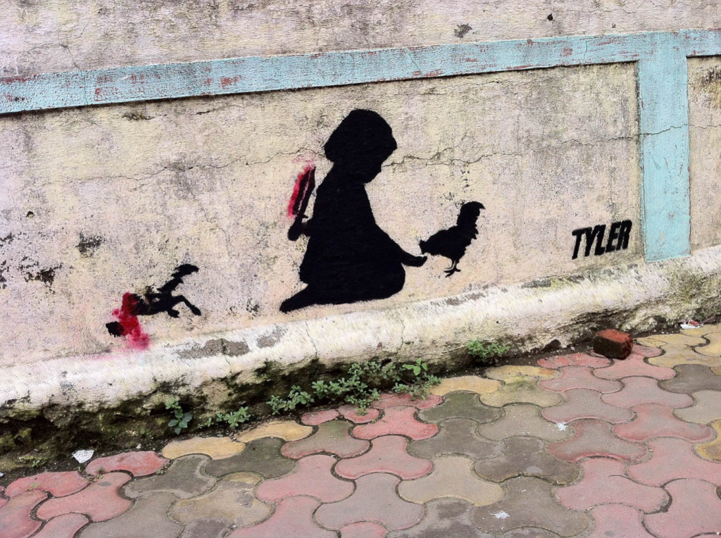 A stencilled work of a girl feeding a chicken with a dagger behind her back, smeared with the blood of another dead chicken. This was done at a spot where a woman used to sell chicken eggs. After this was sprayed, apparently she stopped coming.  Stencils and Spray Paint. Andheri, Mumbai.