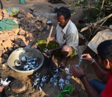 Artisans busy removing the clay substance after firing the objects