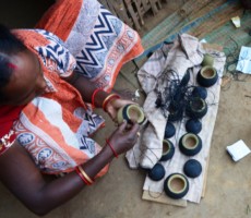 an artisan busy layering the clay mould with wax strips