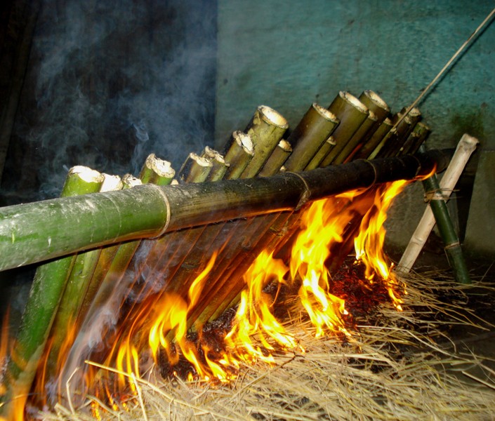 preparing by heating the rice stuffed bamboo cake